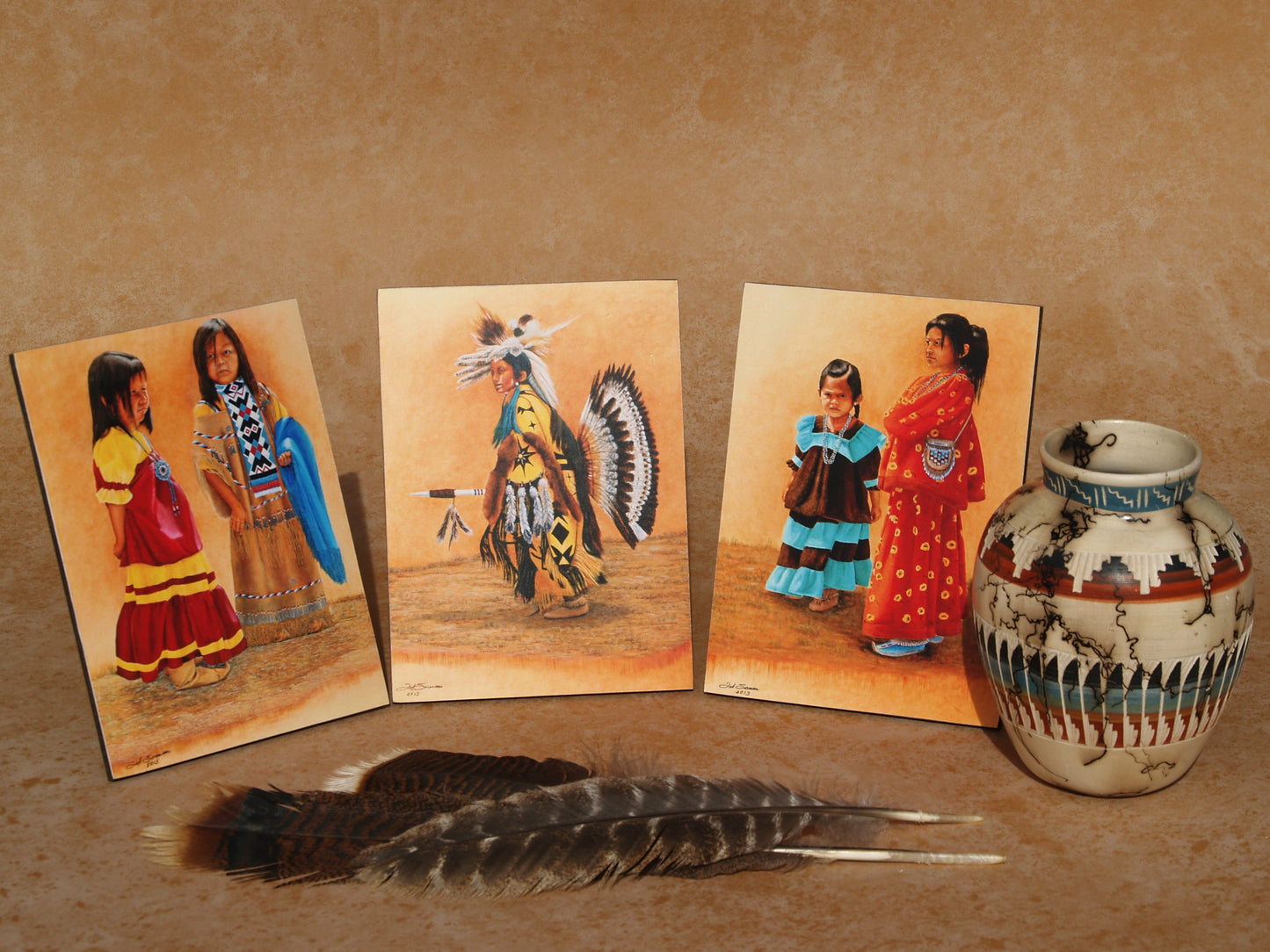 Native American youth art mini panels featuring traditional dress and dance scenes displayed with feathers and pottery