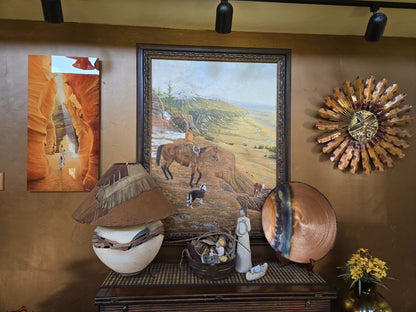Original western oil painting by Ted Sorensen displayed on wall above rustic decor and Native American art pieces